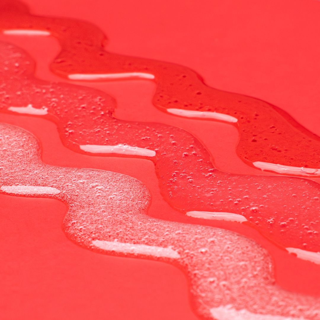 three squiggle lines of Jessicurl Cleansers on a red table