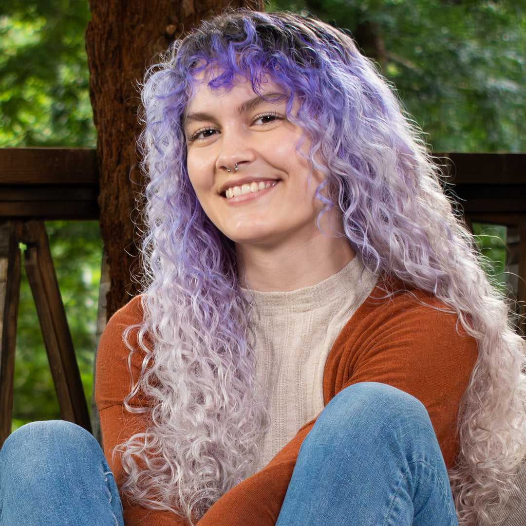 fine haired curly woman smiling and sitting on the porch