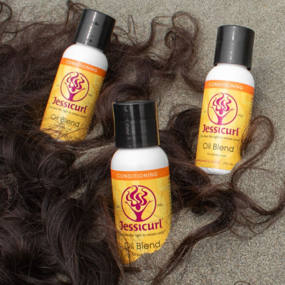 brown curly hair on a sandy beach surrounding three bottles of product