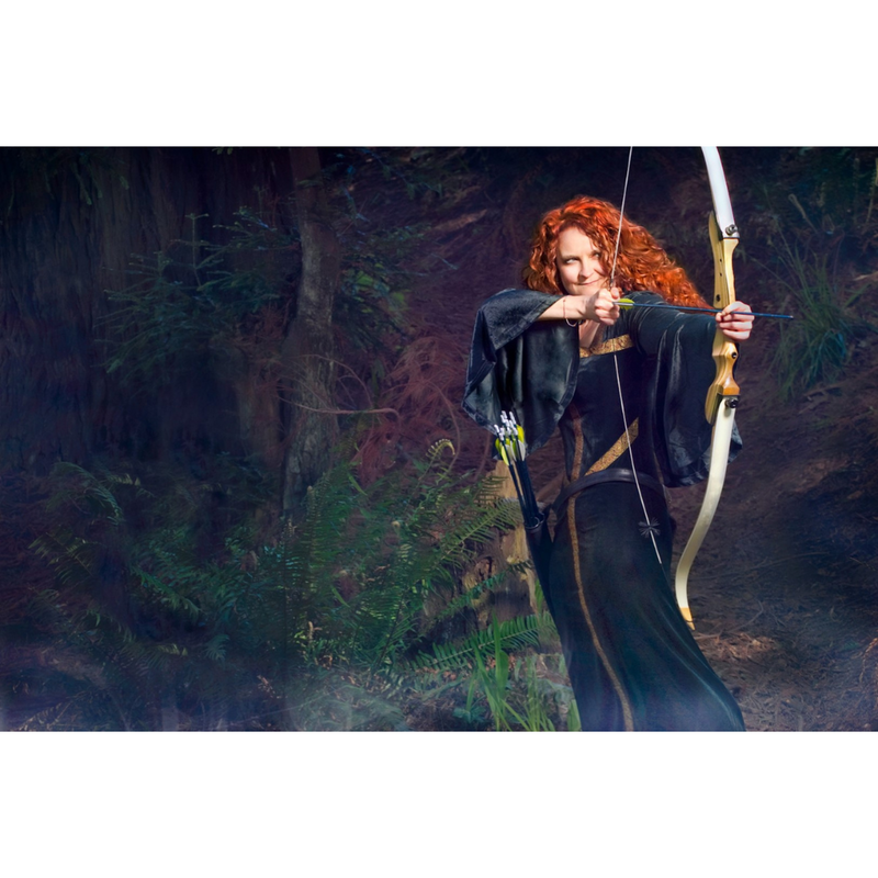 jessicurl founder, Jess McGuinty, dressed as Merida from Brave in a green dress and bow standing in a forest
